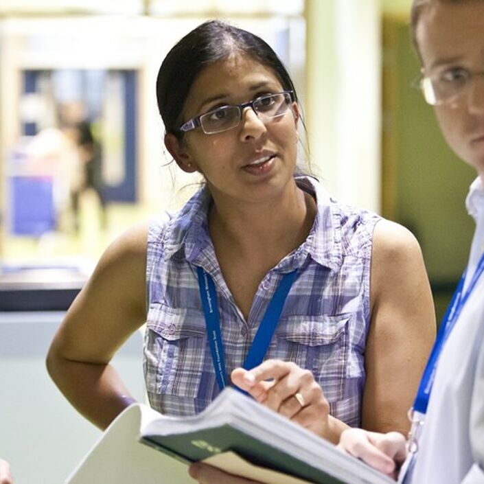 Doctors stood together speaking in a hospital setting