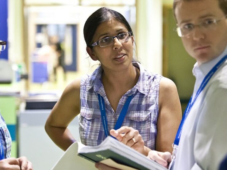 Doctors stood together speaking in a hospital setting