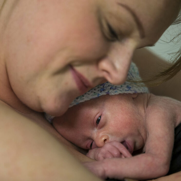 Mum cuddling baby on her chest skin to skin