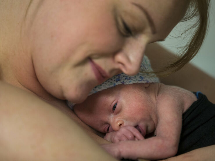 Mum cuddling baby on her chest skin to skin