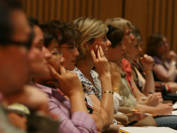 Women sat in an audience looking towards the stage intently