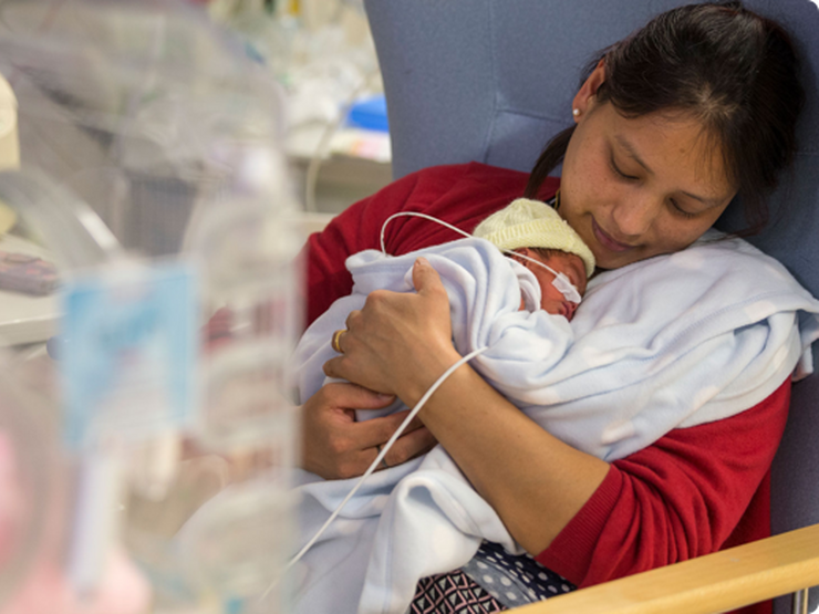 Mother holding her new-born baby in hospital