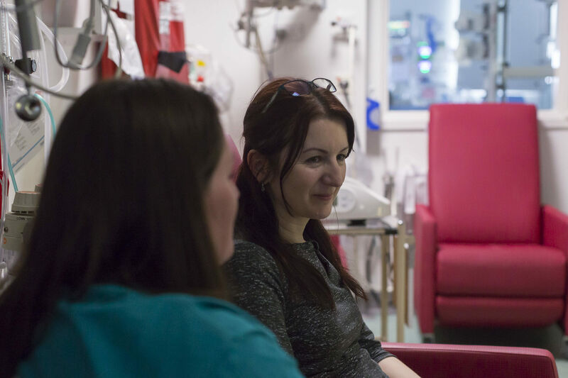 Parent looking away from the camera being supported by a friend looking towards them