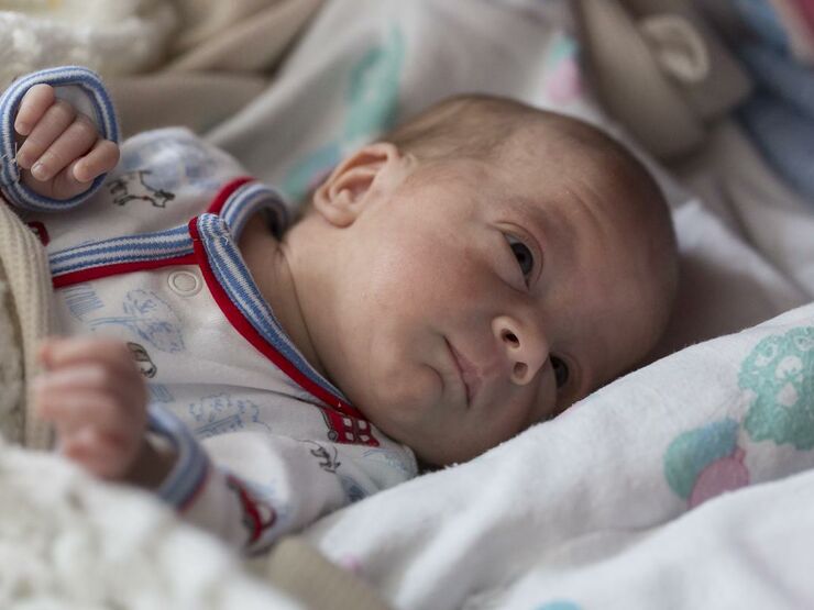 Baby lying comfortably on its bed while awake