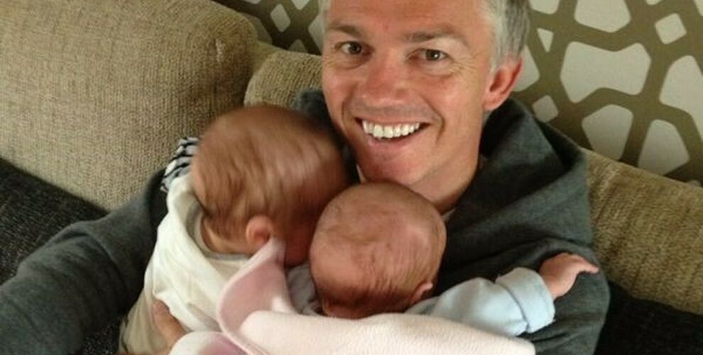 Jason holding his twins at home