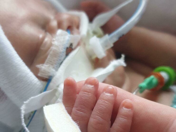 Ethan's baby holding his finger