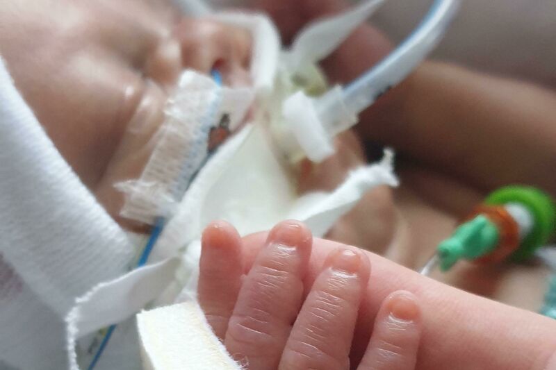 Ethan's baby holding his finger