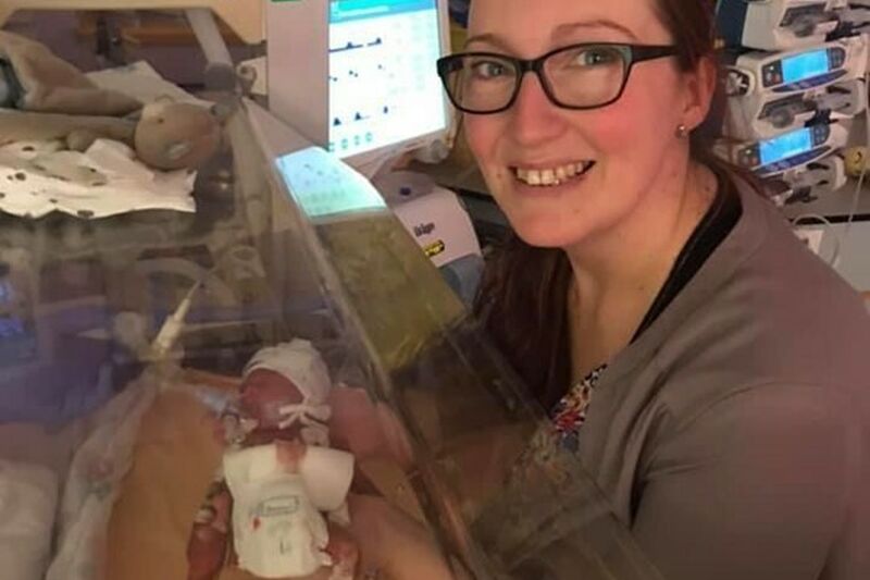 Jennie holding her son Rex, who is in an incubator in NICU