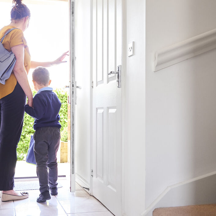Mum and young child at the doorway leaving home for school