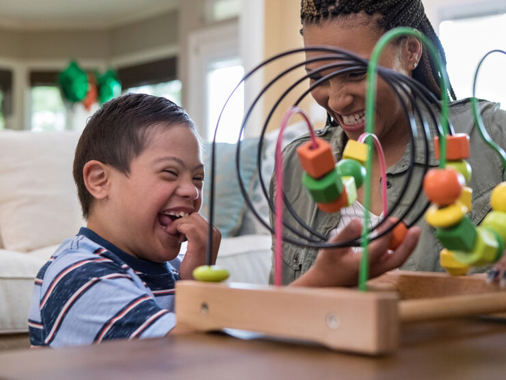 Mum and child happily playing with a toy, smiling and laughing