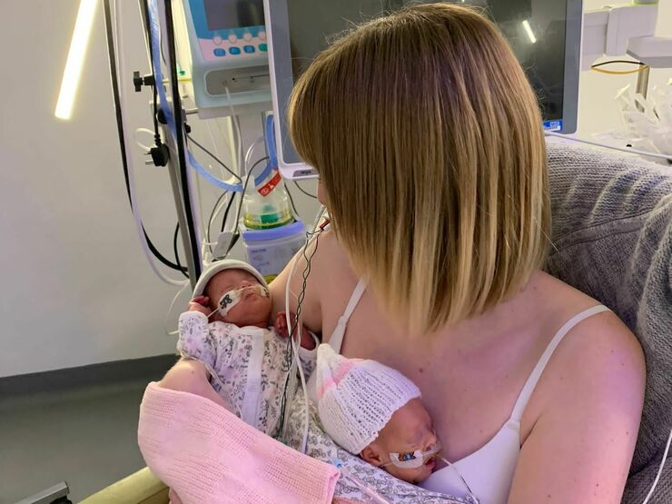 Abbie holding her twins in the NICU