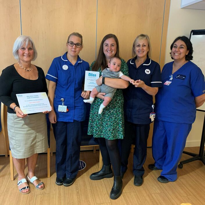 Some of the unit staff and a parent with her baby