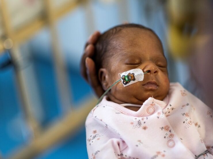 Baby with a feeding tube being held by parent