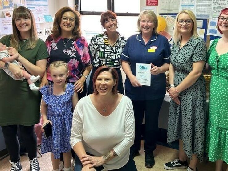 Group photo of members of hospital and Bliss staff. One person in a blue nursing uniform is holding a Bliss Baby Charter plaque.