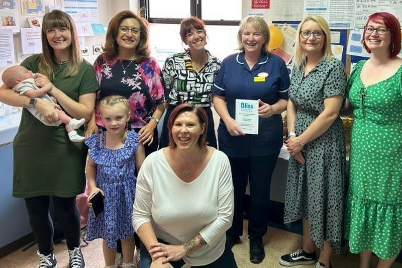 Group photo of members of hospital and Bliss staff. One person in a blue nursing uniform is holding a Bliss Baby Charter plaque.