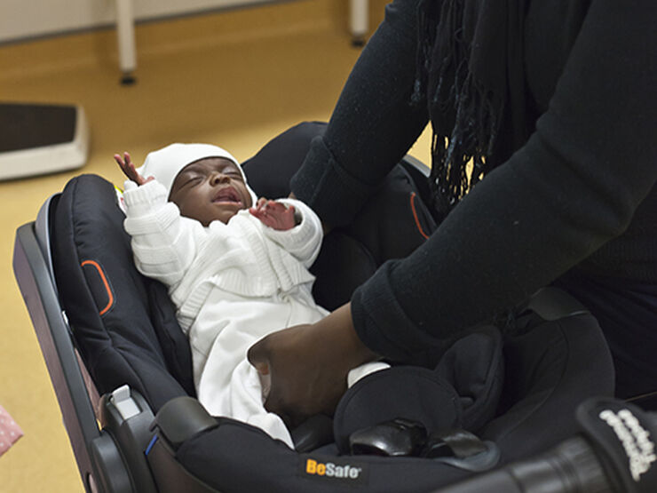 Baby being placed in car seat