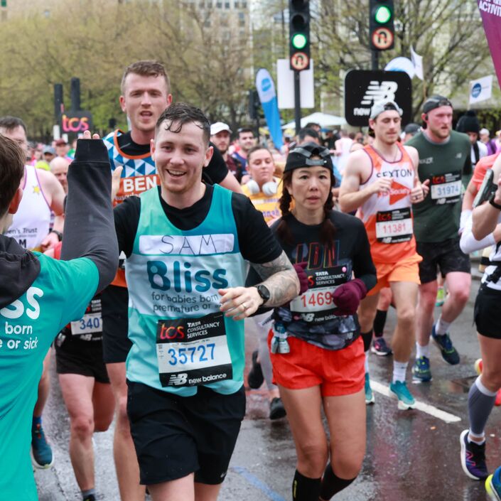 Bliss runner receiving high five while running the london marathon