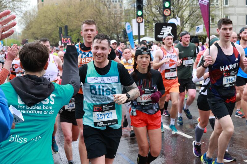 Bliss runner receiving high five while running the london marathon