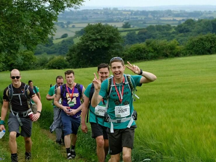 Group of walkers posing to the camera while they walk amongst the countryside