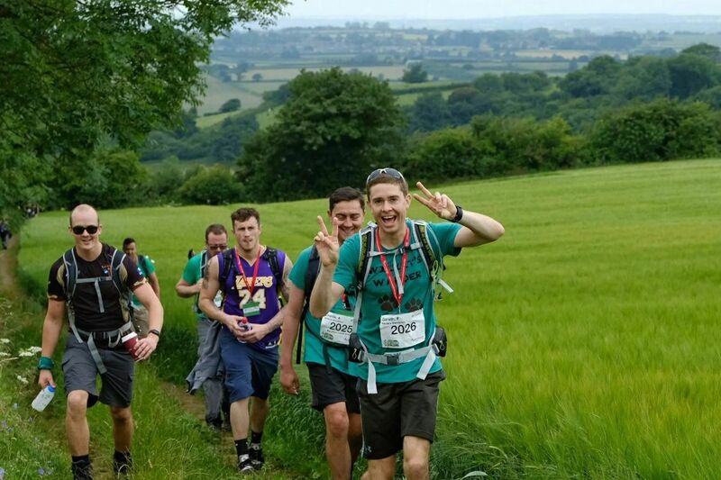 Group of walkers posing to the camera while they walk amongst the countryside