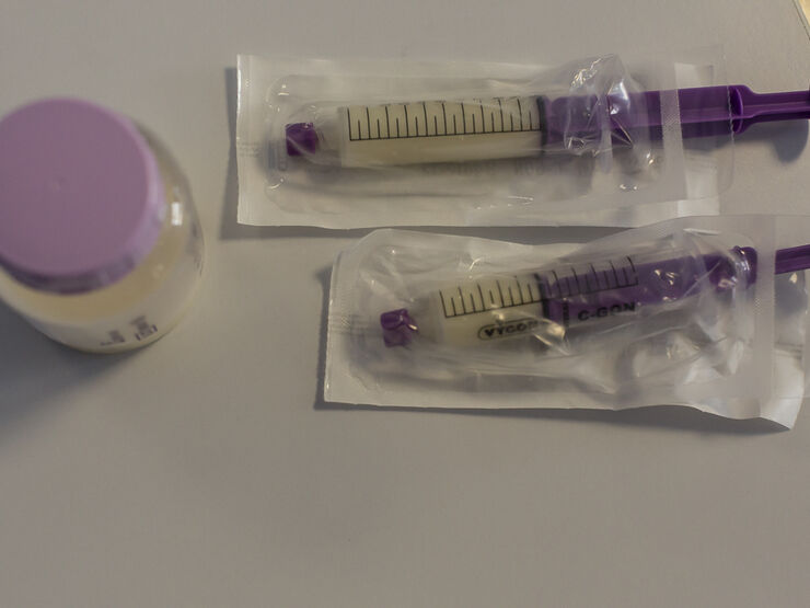 Bottle and two syringes with expressed milk
