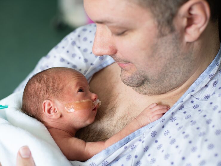 Father taking care of his premature baby doing skin to skin at hospital