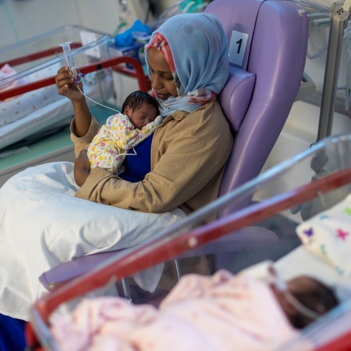 Woman holding her baby in a hospital setting