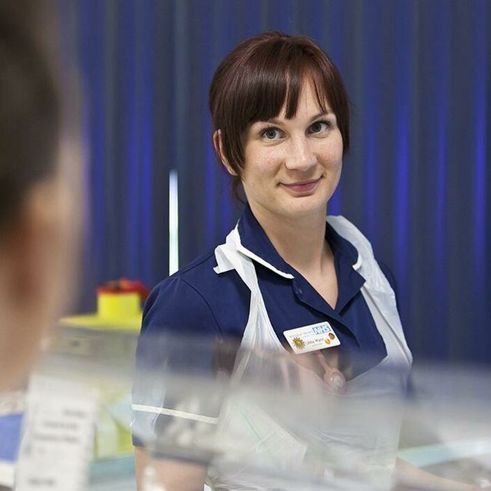 Nurse smiling in a neonatal hospital setting