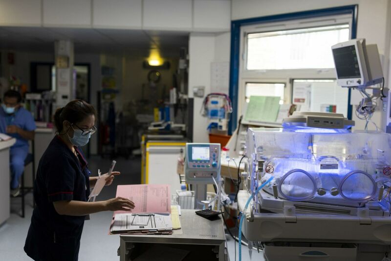A member of unit staff looking through notes in front of an incubator