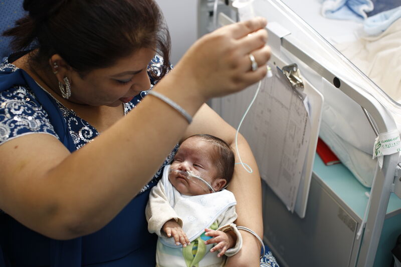 Mother tube-feeding her baby in hospital