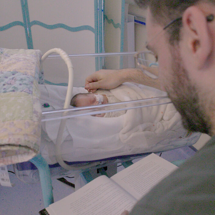 Parent caressing their sleeping baby