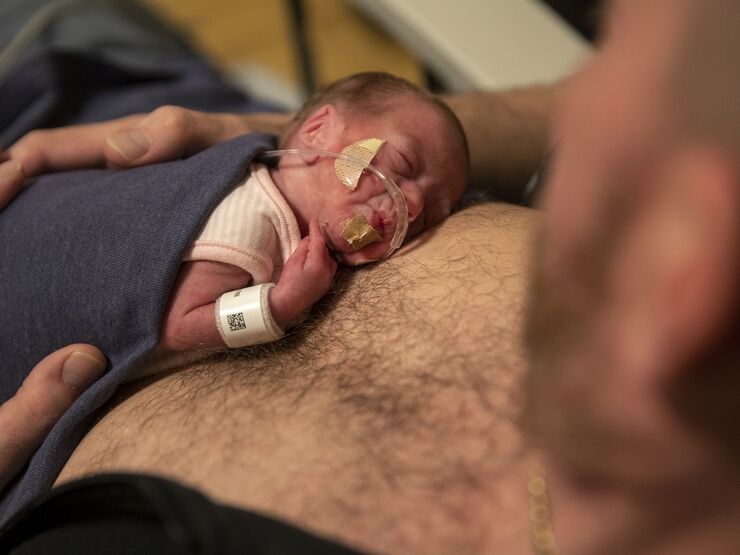 A dad who has baby on chest doing skin to skin care