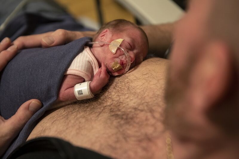 A dad who has baby on chest doing skin to skin care