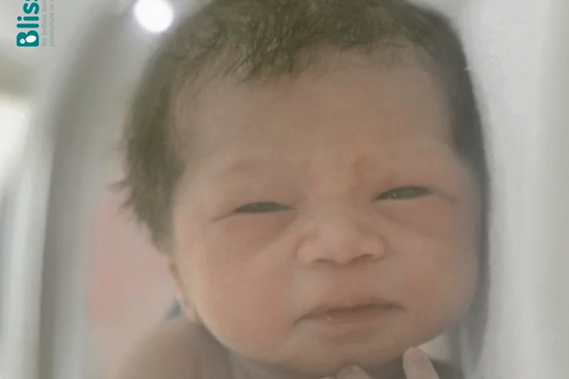 Close up on baby's face - baby has dark hair and features in the video on this webpage