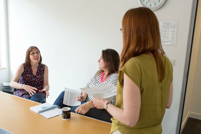 Members of research panel sat around a table talking