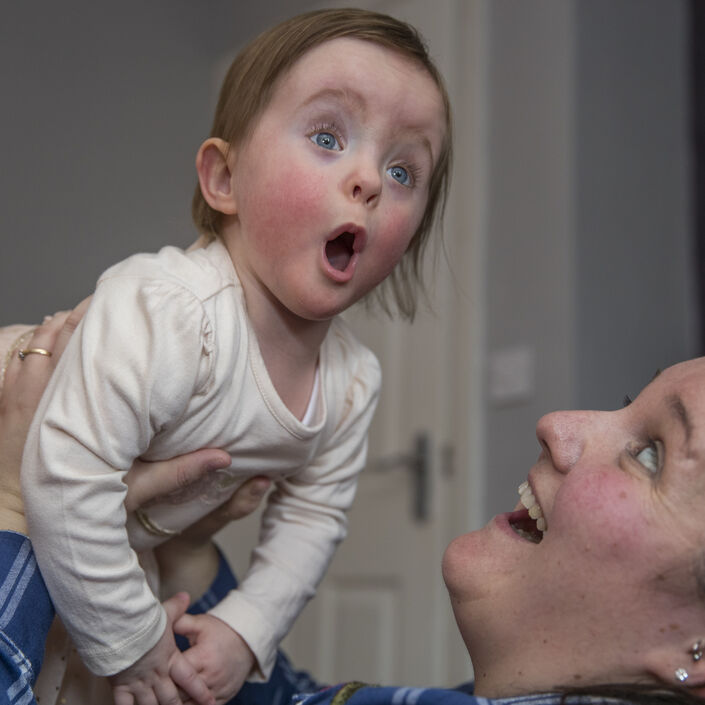Mother lifting up her baby daughter playfully