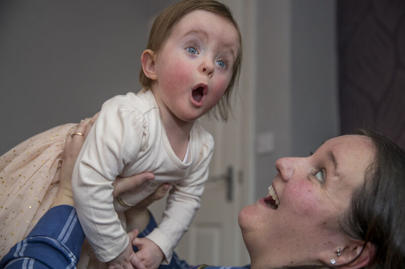 Mother lifting up her baby daughter playfully