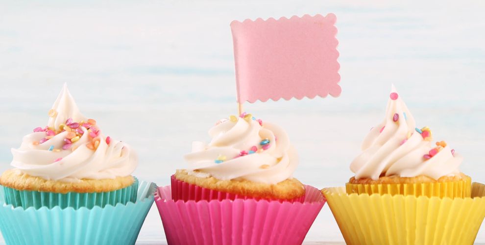 3 cupcakes lined in a row, the middle one has a flag in it