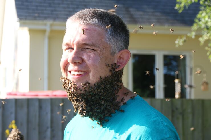 Man with bees swarming around his chin