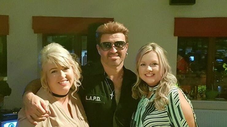 two ladies posing with a George Michael tribute singer