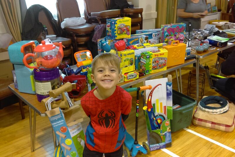 Young boy in spider man costume in front of his toys