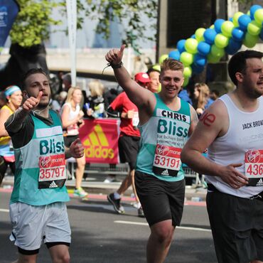 Two Bliss runners celebrating with their arms outstretched