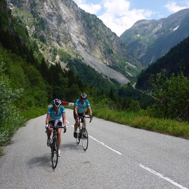 Two Bliss cyclists cycling on road surrounded by mountains