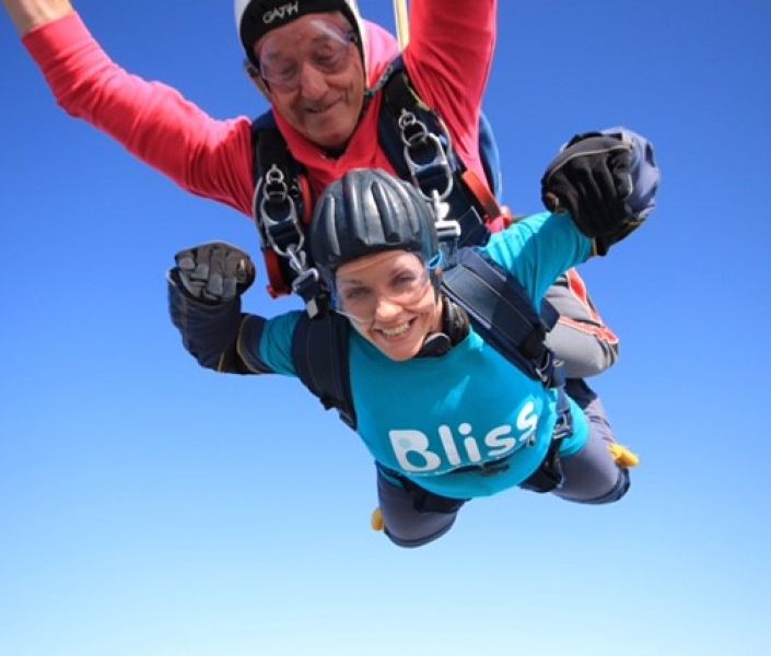 Bliss female fundraiser mid-air during a tandem skydive