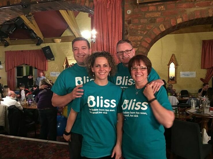 Group of 4 wearing Bliss t-shirts in a venue where they have organised an event