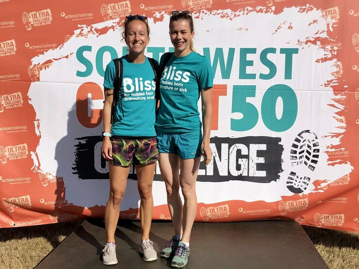 2 bliss walkers in bliss t-shirts on the event podium smiling