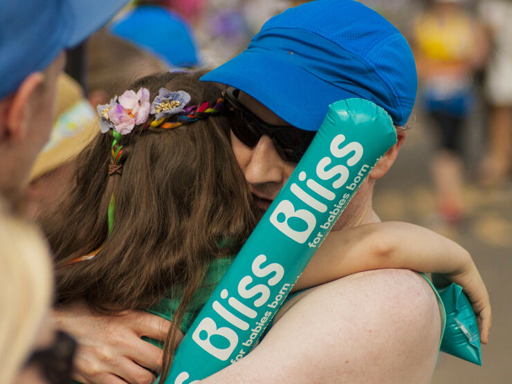 Man taking part in running event hugging a Bliss supporter