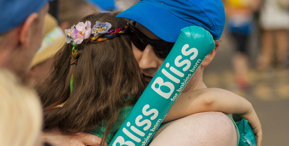 Man taking part in running event hugging a Bliss supporter