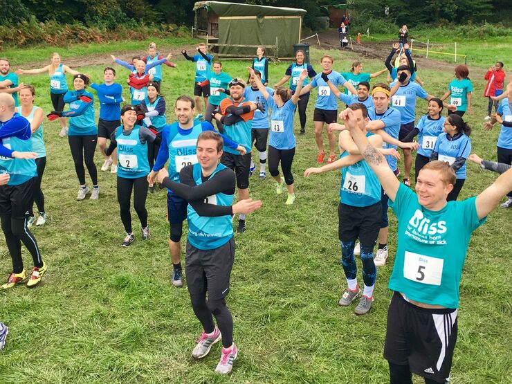 People wearing Bliss t-shirts and vests warming up to take part in a mud run