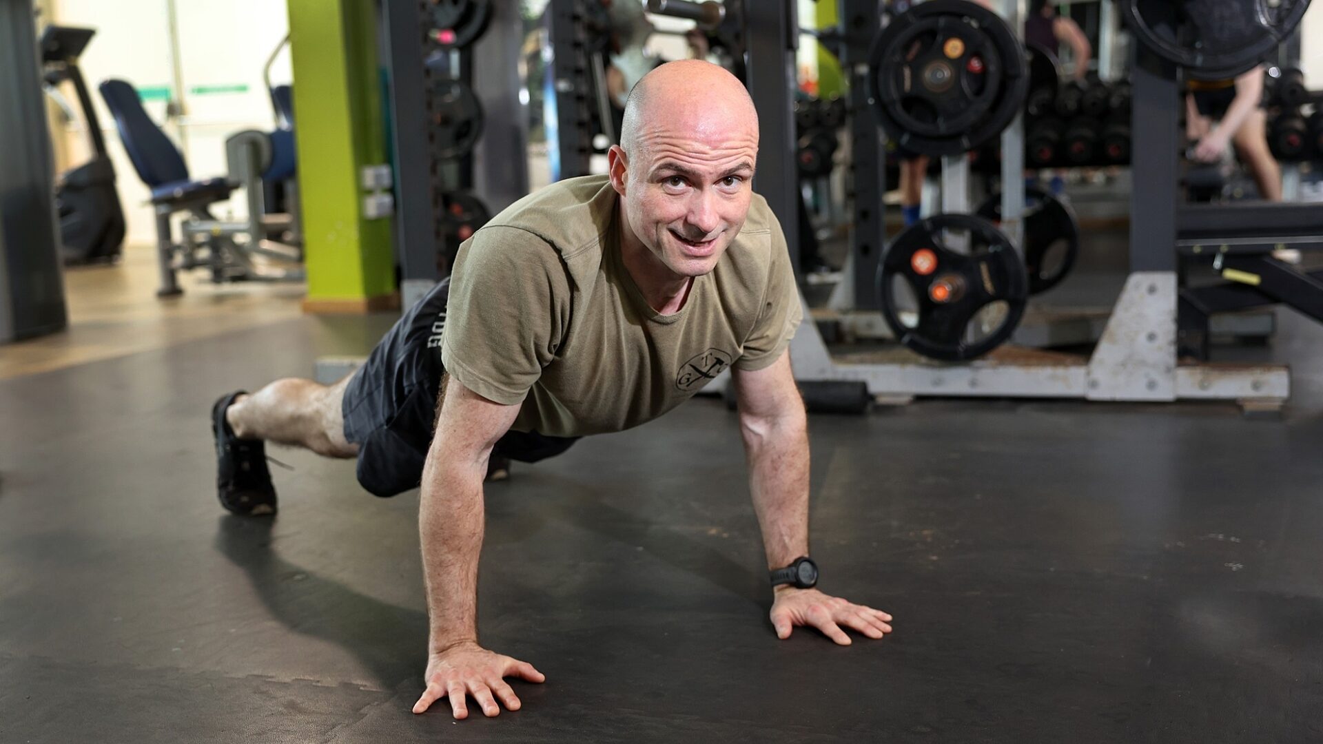 Adult volunteer doing push ups in a gym